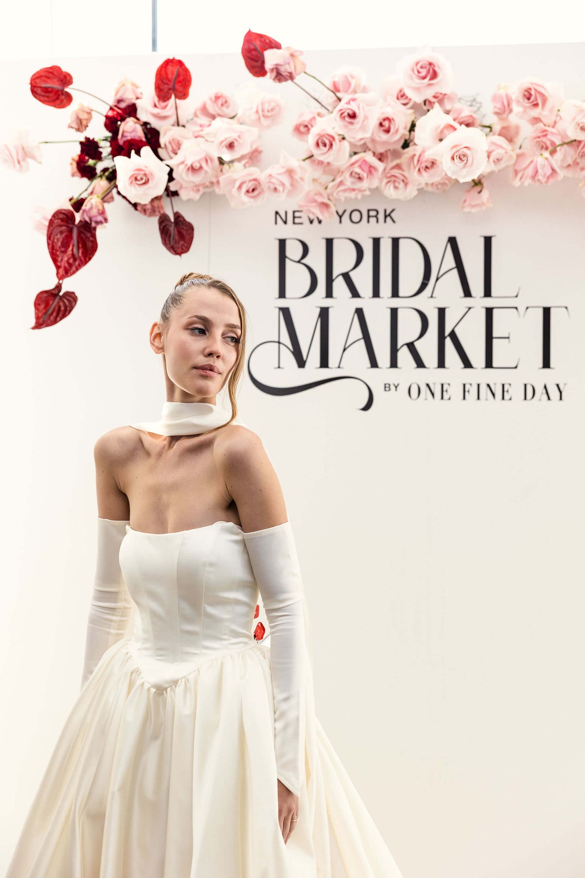 Woman in a bridal gown with flowers at the New York Bridal Market.