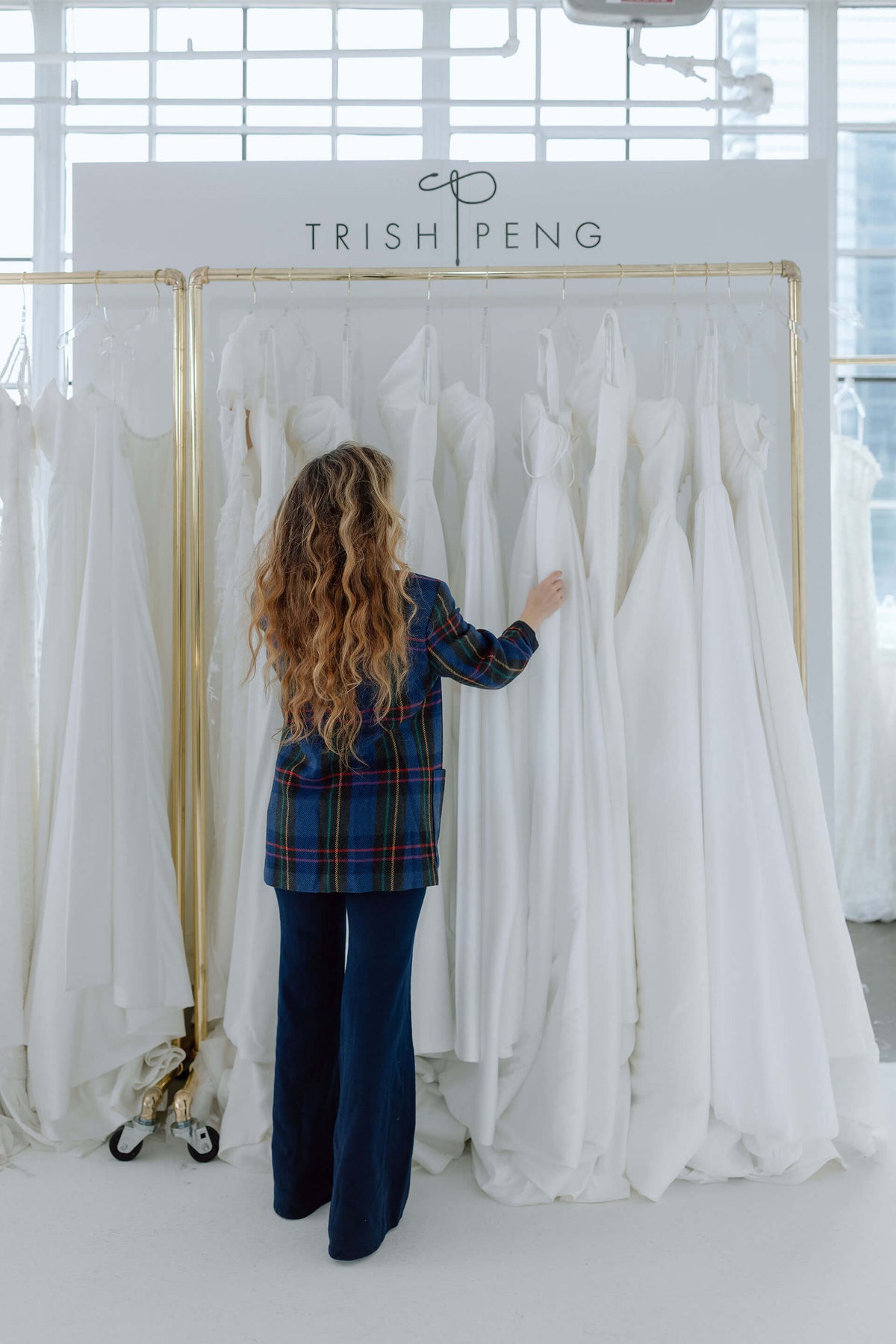 Woman looking at wedding dresses in a Trish Peng showroom at bridal trade show