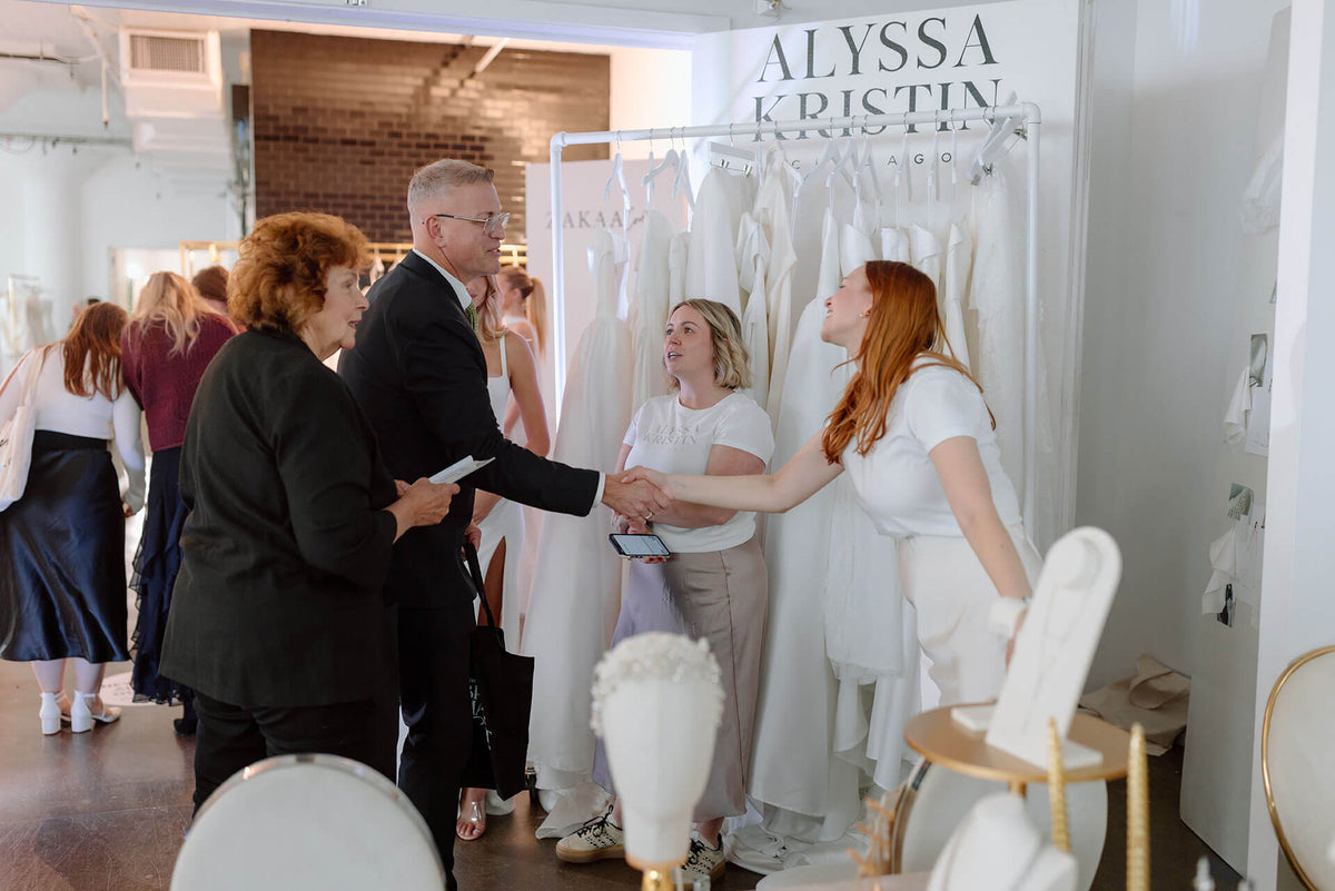 People interacting at a bridal show at Alyssa Kristin's showroom at the bridal trade event in New York