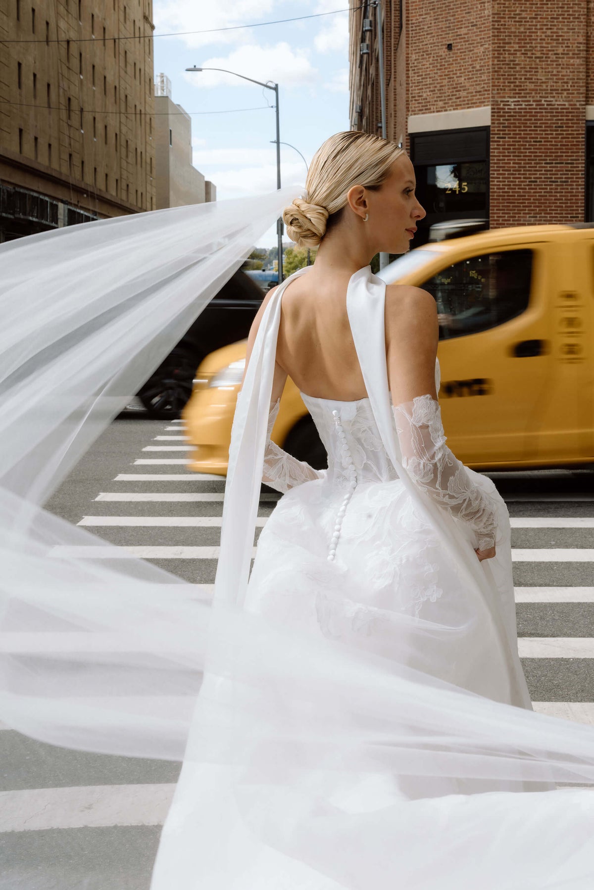 Woman in a white wedding dress running and crossing the street in New York