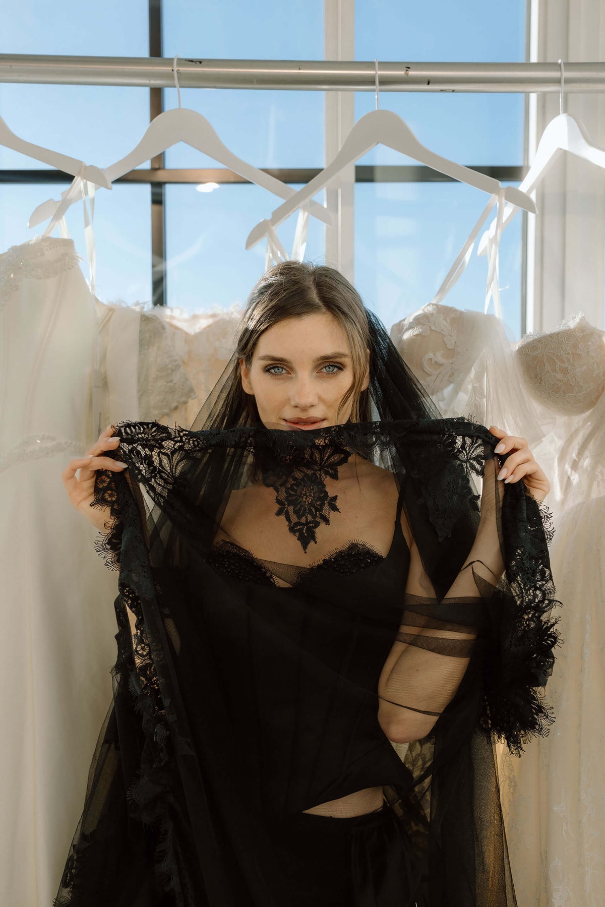 Woman wearing a black lace garment in a bright room with large windows, at the New York bridal market by One Fine Day